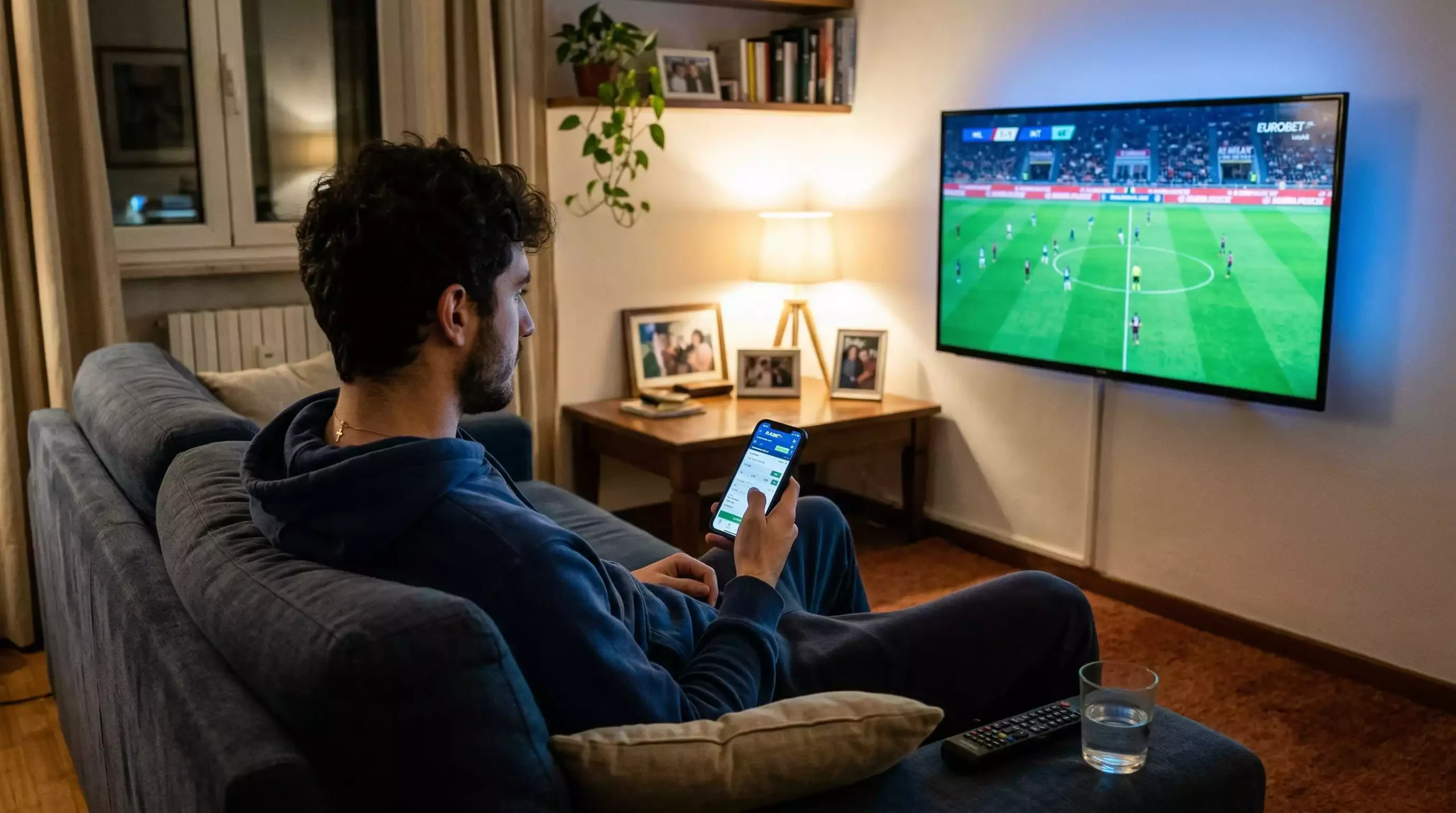 Tifoso che segue una partita dal vivo con smartphone in mano